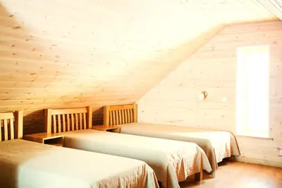 a room with three beds in a wooden cabin at Aitvaras in Anykščiai