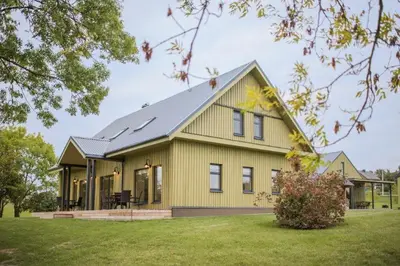a yellow house with a gray roof at Aitvaras in Anykščiai