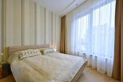 a bedroom with a bed and a large window at 555 SoleSun in Druskininkai