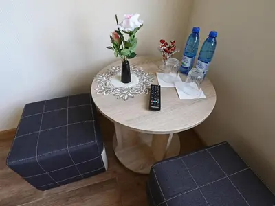 a table with a vase of flowers and water bottles at Juro Guest House in Šiauliai