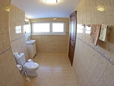 a large bathroom with a toilet and a shower at Juro Guest House in Šiauliai