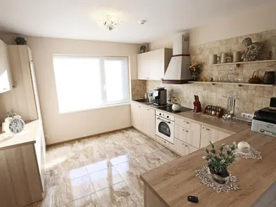a kitchen with a table and a large window at Juro Guest House in Šiauliai