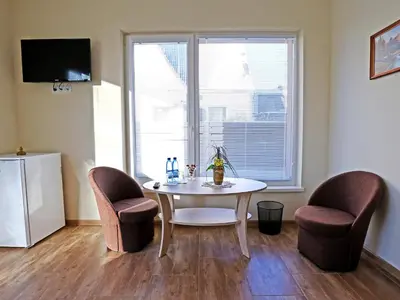 a dining room with a table and two chairs and a window at Juro Guest House in Šiauliai