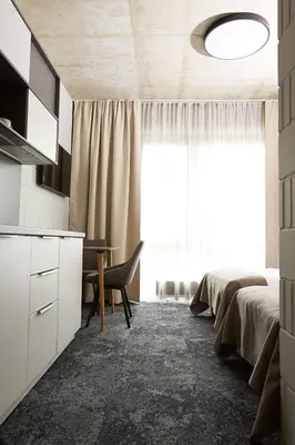 a bedroom with a bed and a desk and a window at Air Hotel in Karmėlava