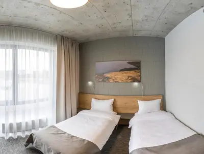 two beds in a room with a window at Air Hotel in Karmėlava