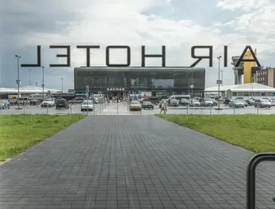 a parking lot with a large sign in front of a building at Air Hotel in Karmėlava