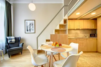 a living room and kitchen with a table and chairs at Sodu15 Apartments in Vilnius
