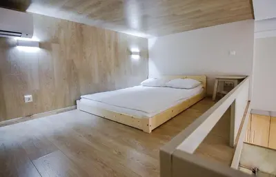 a bedroom with a bed in a room with wooden floors at Sodu15 Apartments in Vilnius