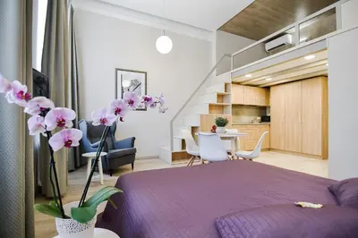 a bedroom with a purple bed and flowers in a room at Sodu15 Apartments in Vilnius