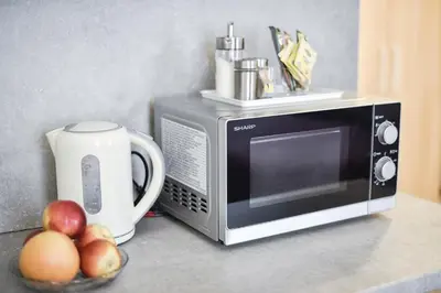 a microwave and a bowl of fruit on a counter at Sodu15 Apartments in Vilnius