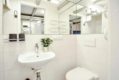 a white bathroom with a sink and a toilet at Sodu15 Apartments in Vilnius