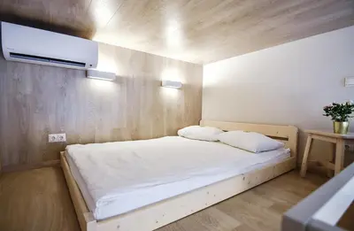 a small bedroom with a white bed and a tv at Sodu15 Apartments in Vilnius
