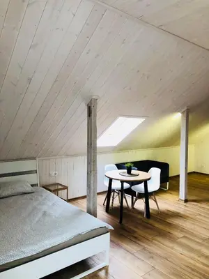 a bedroom with a bed and a table and chairs at Villa Midesta in Šiauliai