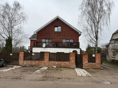 a red brick house with a fence in front of it at Villa Midesta in Šiauliai