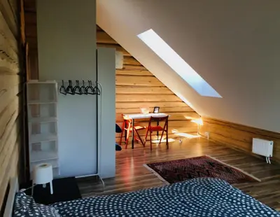a bedroom with a bed and a table in a room at Room in a Scandinavian Style House in Vilnius
