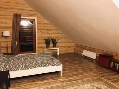 a bedroom with wooden walls and a bed and a window at Room in a Scandinavian Style House in Vilnius