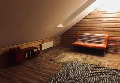 an attic room with a bench and a bed at Room in a Scandinavian Style House in Vilnius