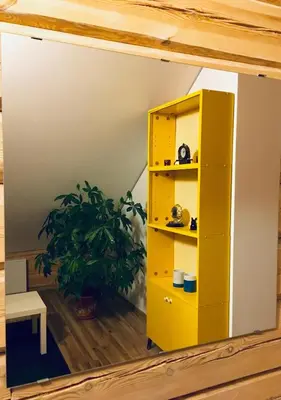 a yellow cabinet in a room with a plant at Room in a Scandinavian Style House in Vilnius