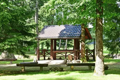 a gazebo in a park with two benches at Auksinis Ąžuolas in Avižieniai