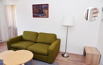 a living room with a green couch and a table at Nijole ir Algimantas in Anykščiai