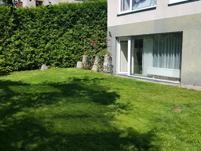 a yard with green grass and a building at Jaukūs apartamentai Free parking in Vilnius