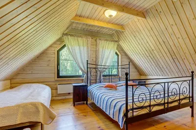 a bedroom with a bed in a log cabin at Country house Stirnamis in Mindūnai