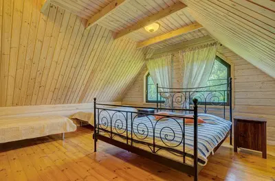 a bedroom with a bed in a room with wooden walls at Country house Stirnamis in Mindūnai
