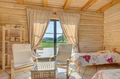 a bedroom with two chairs and a bed and a window at Country house Stirnamis in Mindūnai