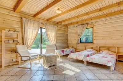 a log cabin with two beds and a chair at Country house Stirnamis in Mindūnai