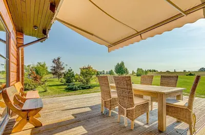 a patio with a table and chairs on a deck at Country house Stirnamis in Mindūnai