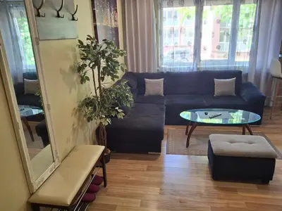 a living room with a blue couch and a table at Apartamentai Dana in Birštonas