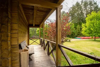 a porch of a log cabin with a bench on it at Pas Kaziuką namukas in Palūšė