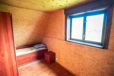 a small room with a bunk bed and a window at Pas Kaziuką namukas in Palūšė