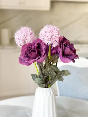 a white vase filled with purple flowers on a table at FoRest Apartments in Druskininkai