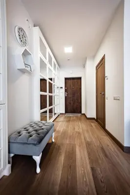 a large hallway with a blue ottoman and a door at FoRest Apartments in Druskininkai