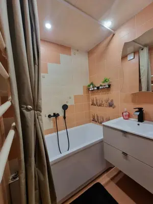 a bathroom with a bath tub and a sink at Airida Forest Apartment in Druskininkai