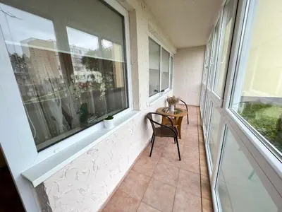 a balcony with a table and chairs and a window at Airida Forest Apartment in Druskininkai