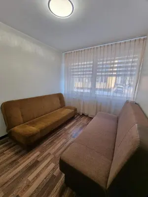 a living room with a couch and a window at Airida Forest Apartment in Druskininkai
