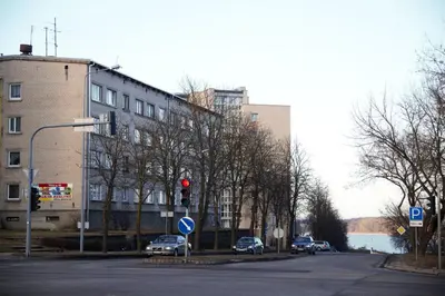 a red traffic light on a city street with buildings at Siauliai Apartments - Ežero in Šiauliai