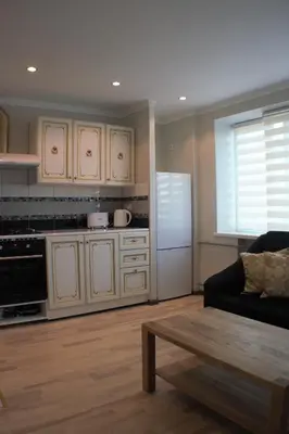 a living room with a couch and a kitchen at Siauliai Apartments - Ežero in Šiauliai
