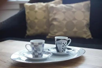 two coffee cups on a plate on a table at Siauliai Apartments - Ežero in Šiauliai