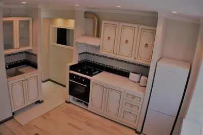 a kitchen with white cabinets and a white refrigerator at Siauliai Apartments - Ežero in Šiauliai
