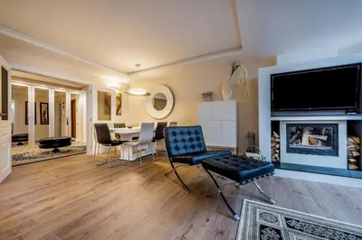 a living room with a fireplace and a dining room at Hills Park Luxury Apartment in Vilnius