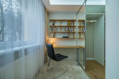 a room with a desk and a chair next to a window at Hills Park Luxury Apartment in Vilnius