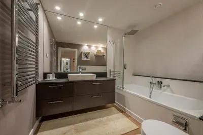 a bathroom with a sink and a tub and a toilet at Hills Park Luxury Apartment in Vilnius