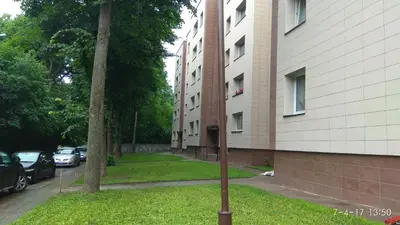 a street sign in the grass next to a building at Hills Park Luxury Apartment in Vilnius