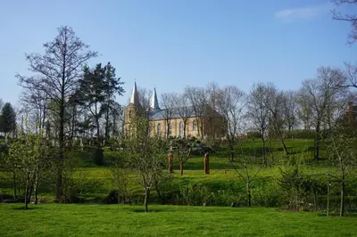 a large building in a field with trees and grass at Atostogų namelis Druskininkuose in Druskininkai