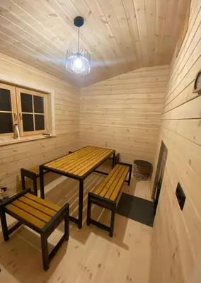 two tables and benches in a sauna at Atostogų namelis Druskininkuose in Druskininkai