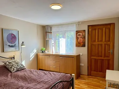 a bedroom with a bed and a dresser and a window at Little house in Kaunas