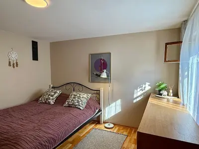 a bedroom with a bed with a purple bedspread at Little house in Kaunas